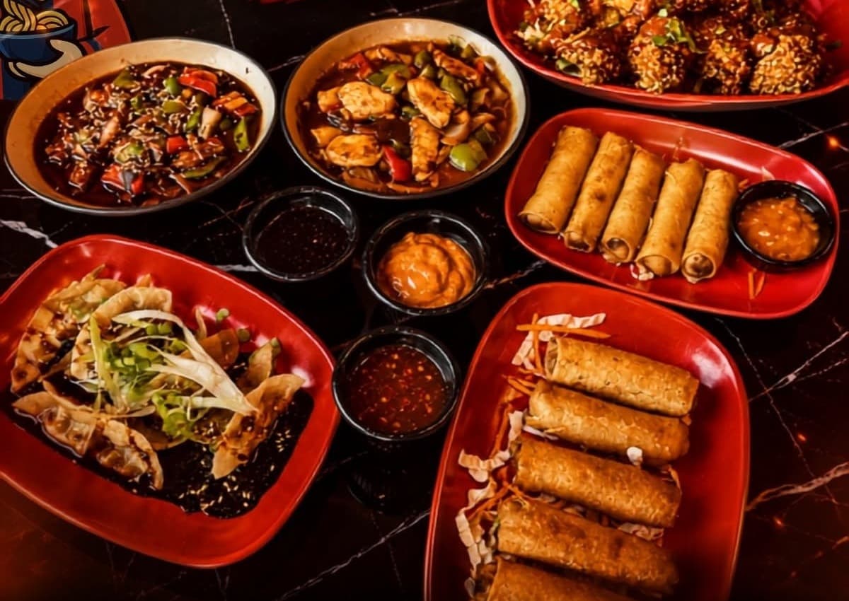 A spread of Fresh Noodles dishes: beef, chicken stir-fry, wings, spring rolls and dumplings